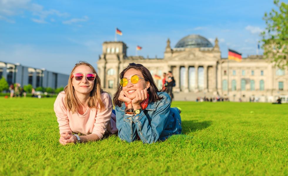 Two,Young,Happy,Girls,Wearing,Sun,Glasses,Lying,On,A